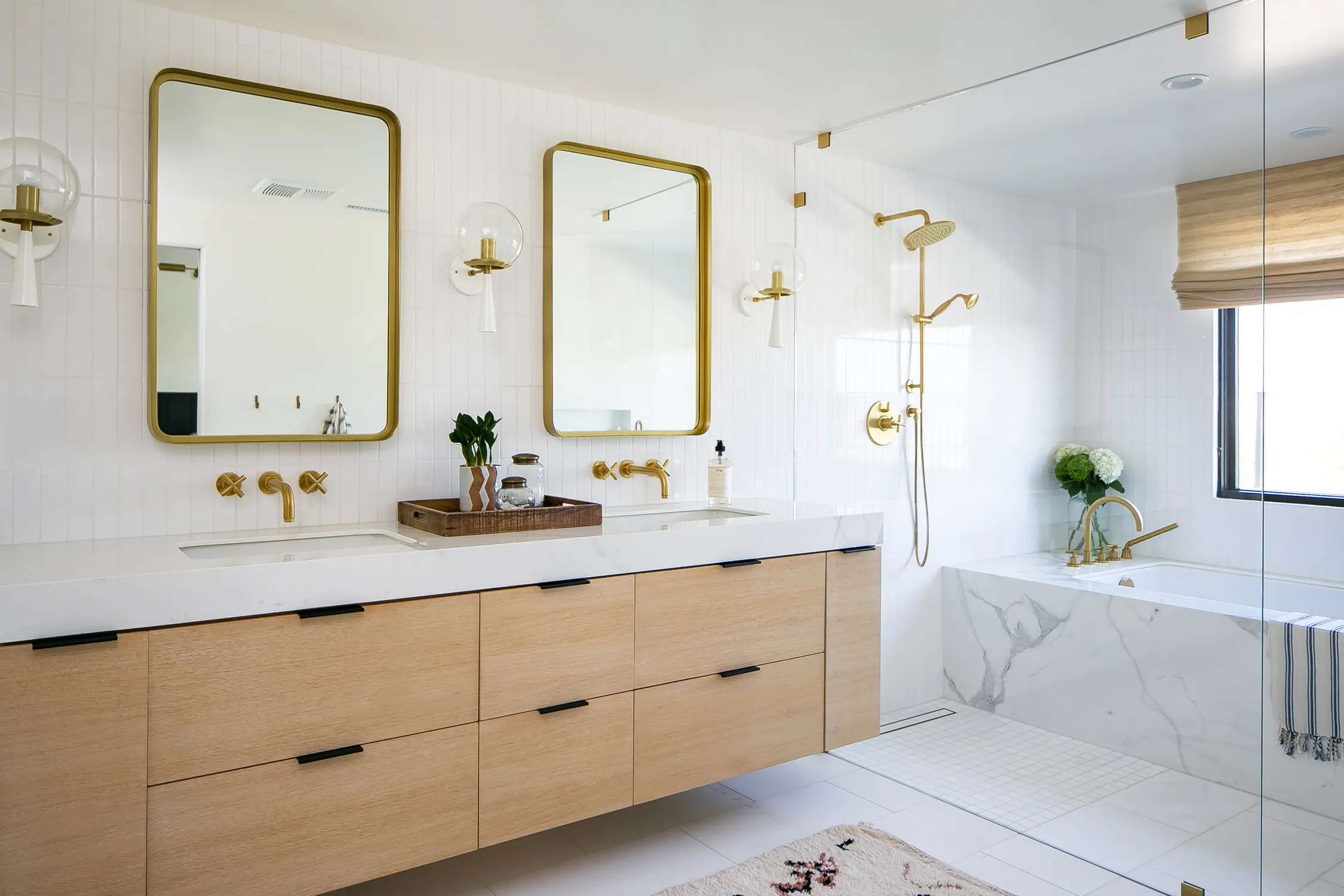 White bathroom with a light-wood double vanity and freestanding tub