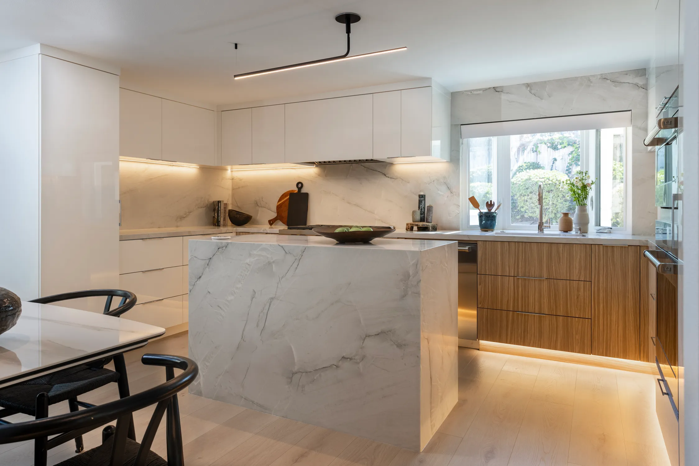 Modern kitchen with marble island and warm wood cabinetry