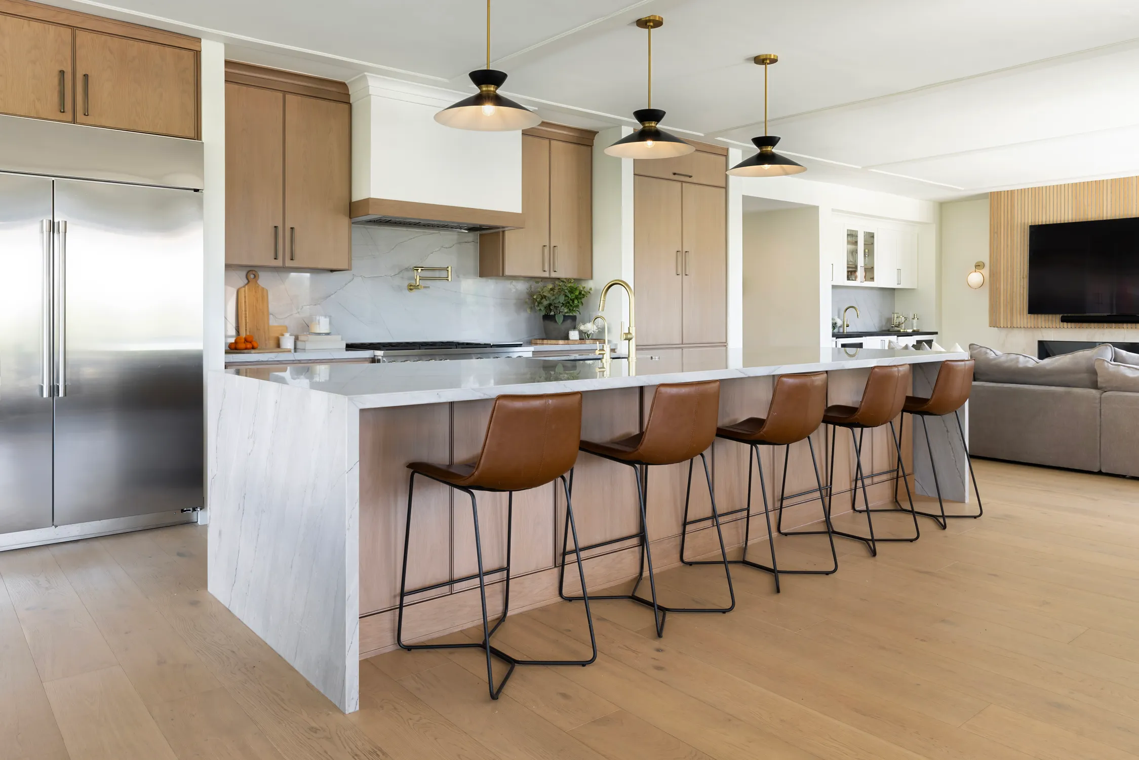 Light-wood kitchen island with four leather bar stools