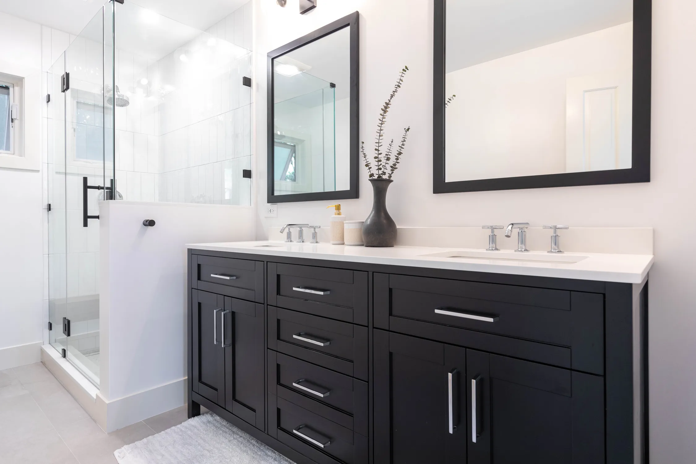 Black double vanity with round mirrors and bathtub