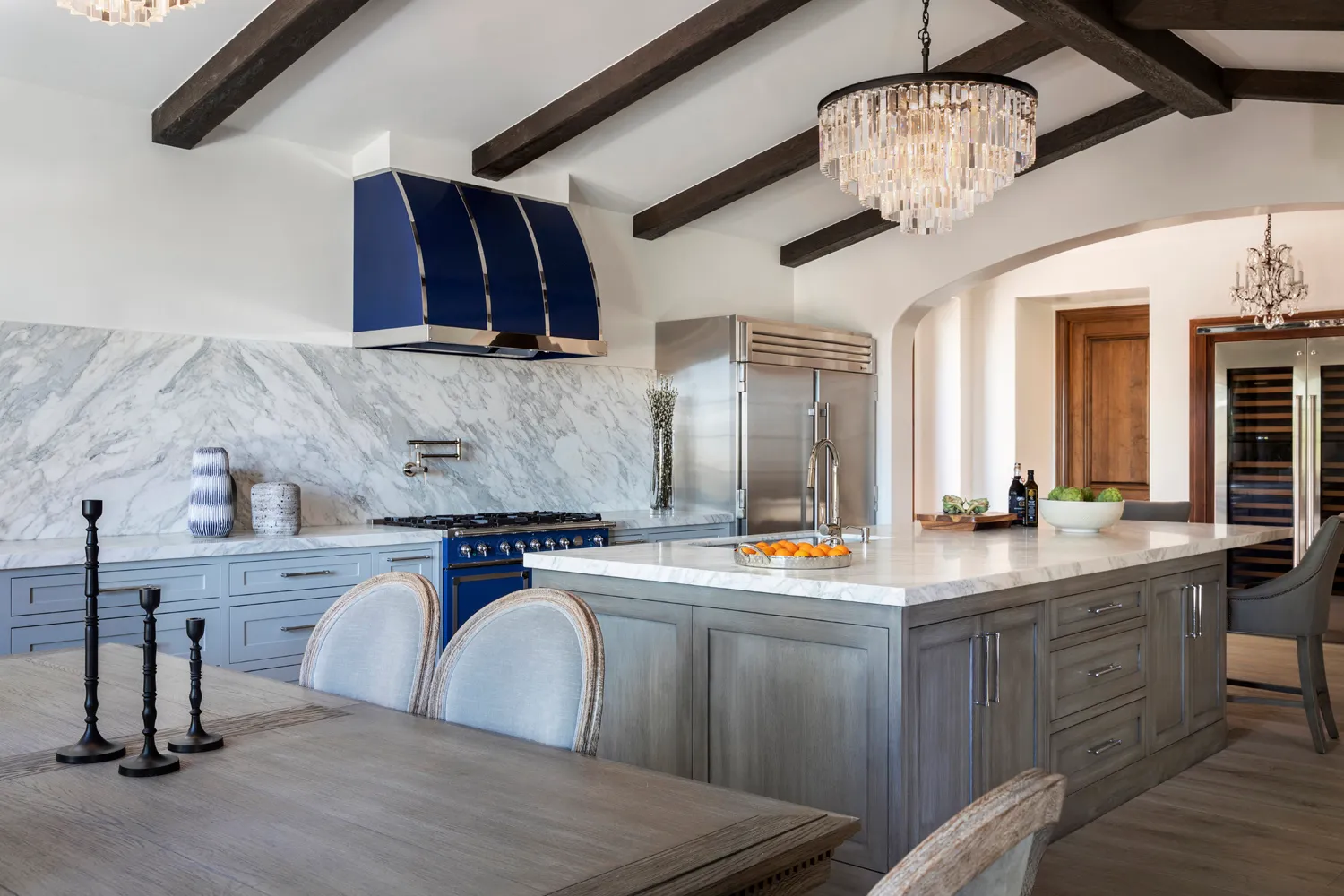 Gray kitchen with marble backsplash, blue range hood, and island