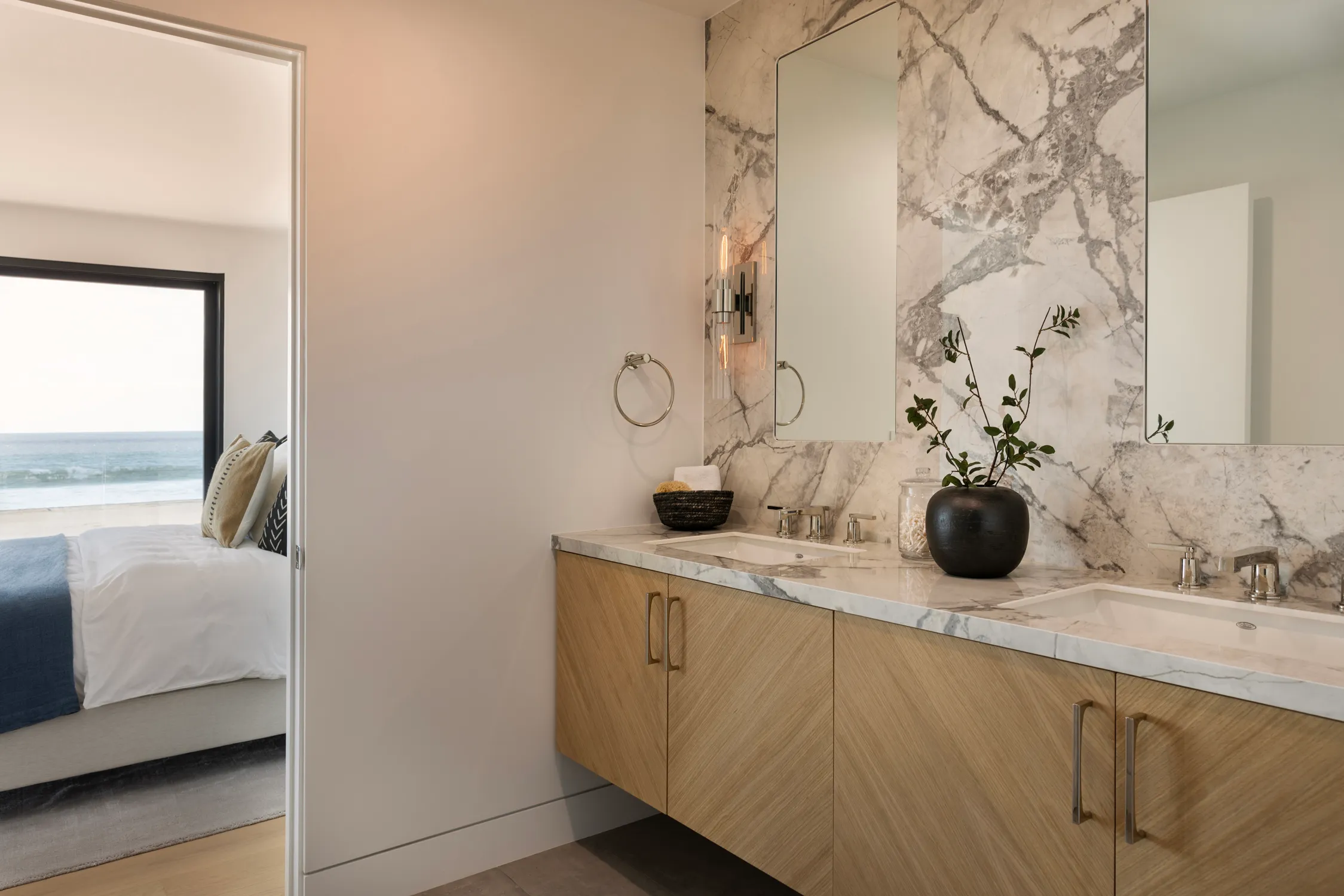 Marble feature wall above a light-wood bathroom vanity
