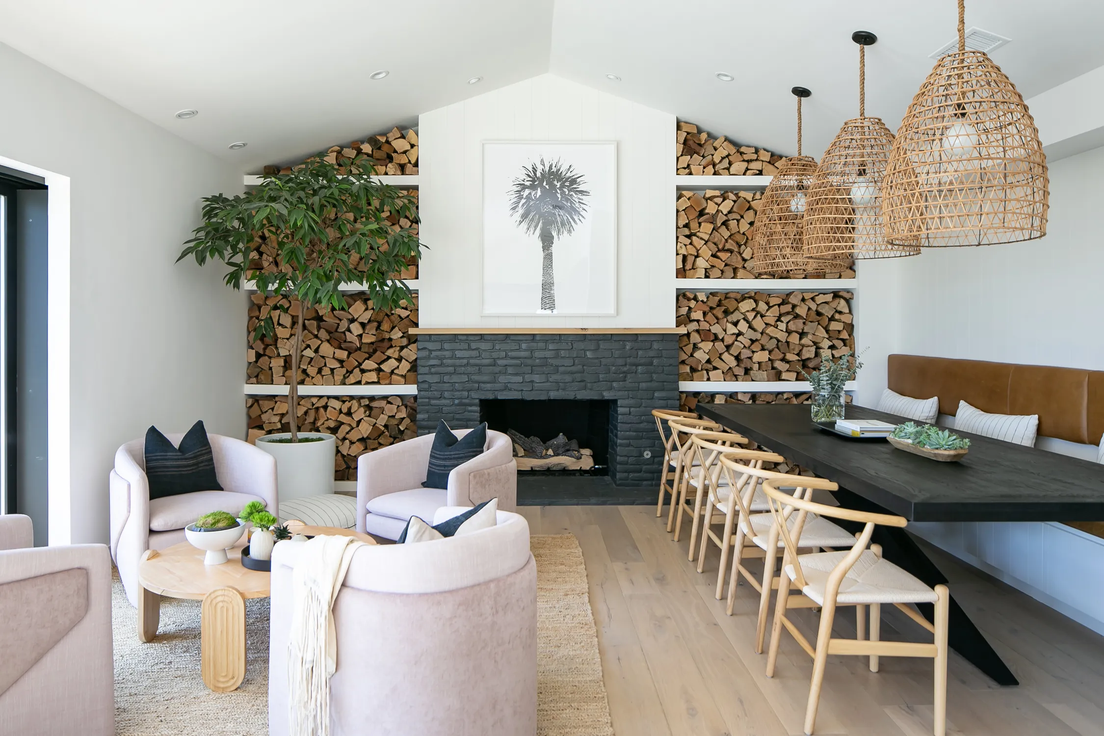 Living room with wood storage wall and woven pendant lights