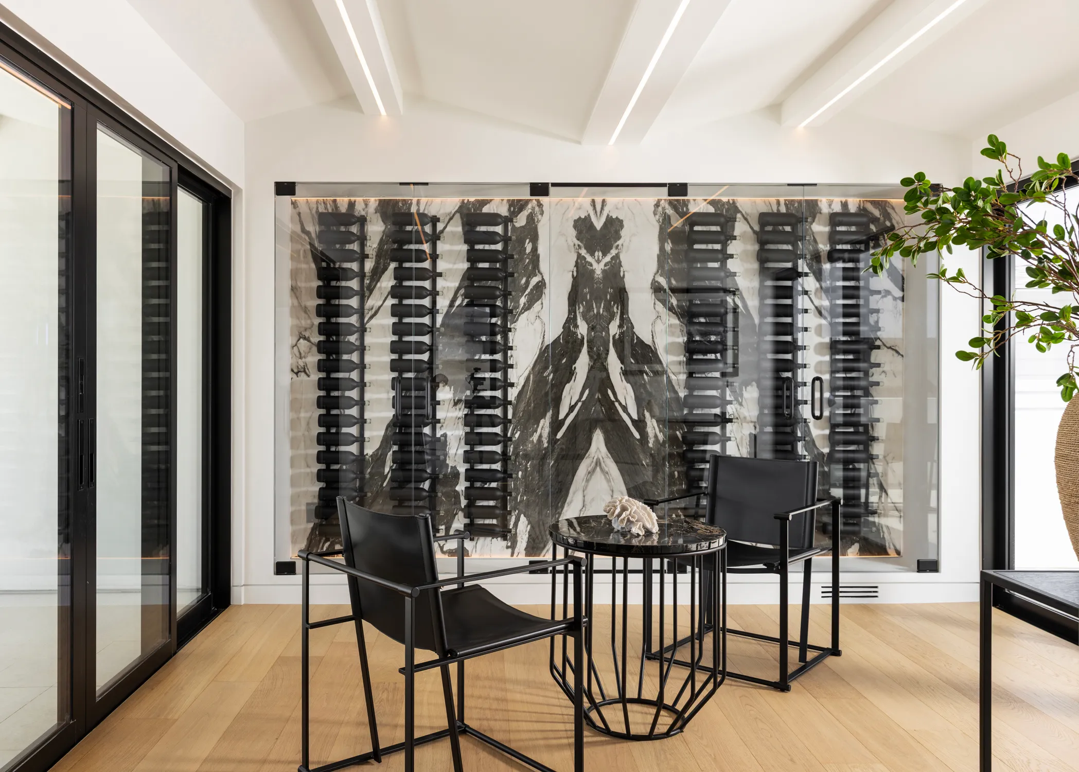 Wine display wall beside a black dining table