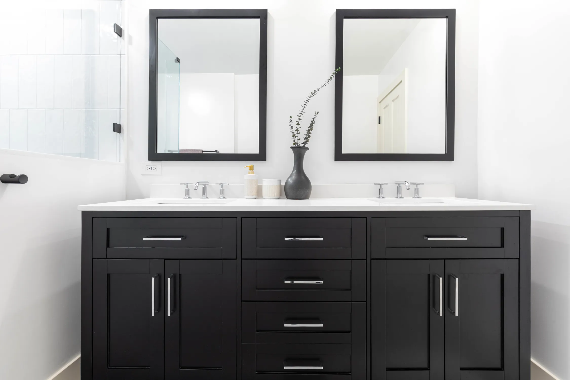 Black double vanity with white countertop and round mirrors