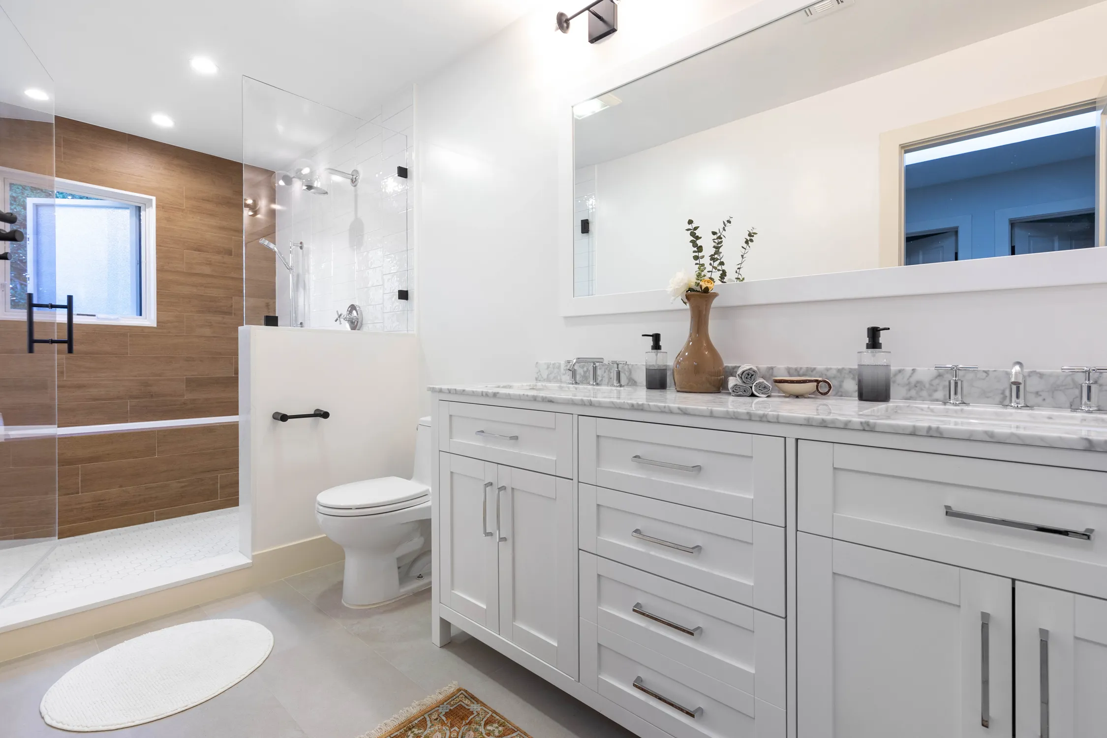 Light-gray double vanity beside freestanding tub and glass shower