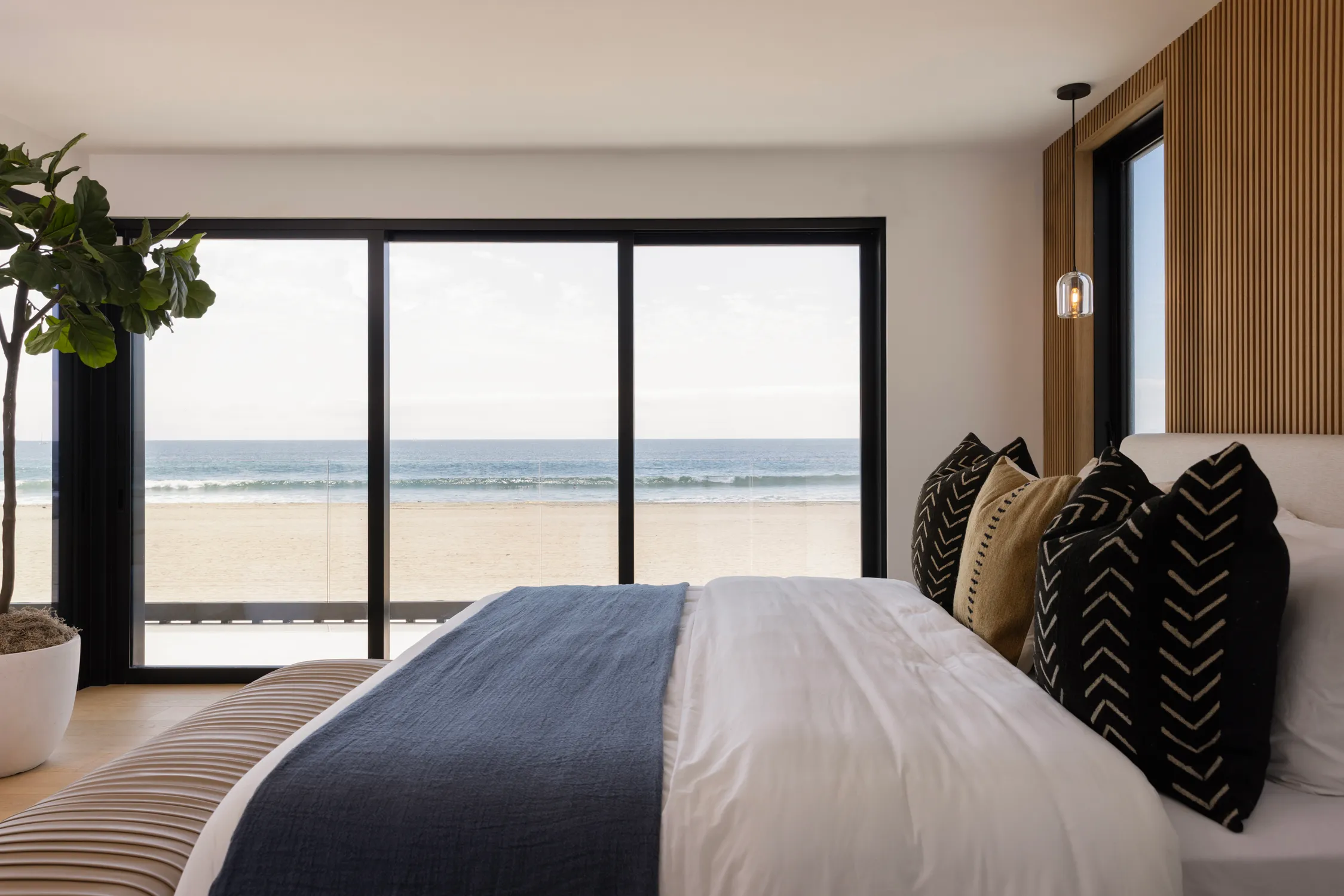 Ocean-view bedroom with black-framed sliding doors