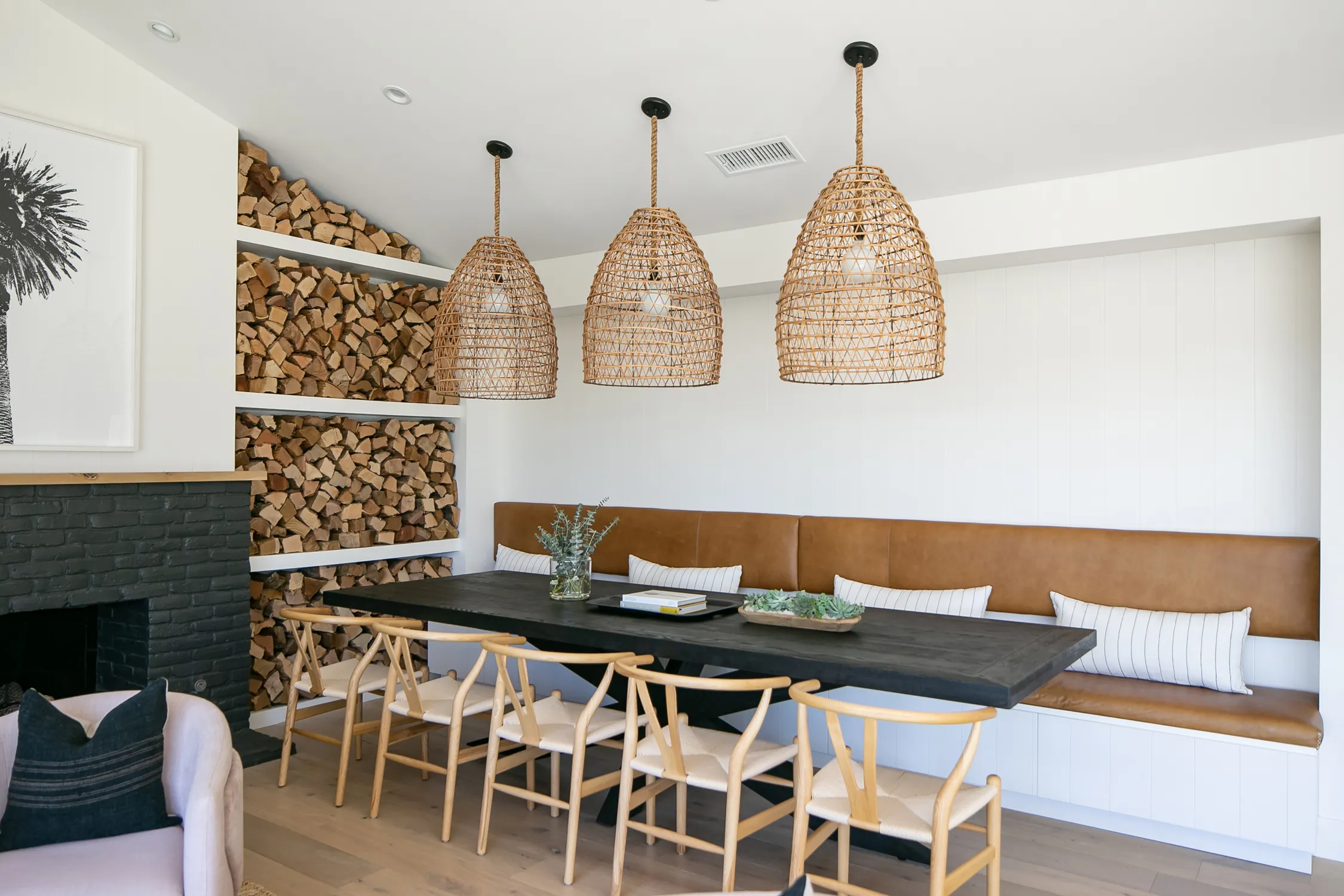 Dining nook with woven pendants and stacked firewood