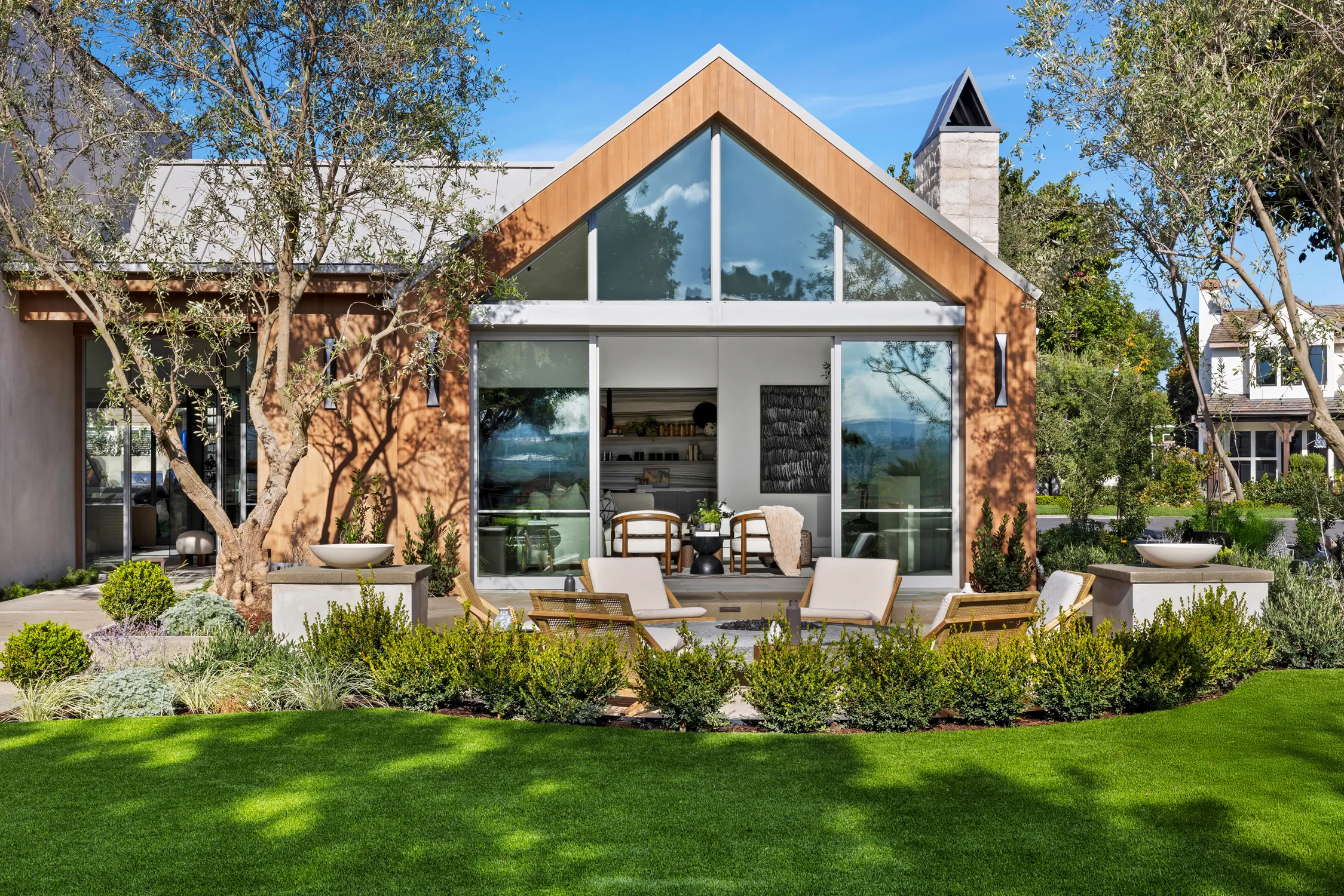 Modern custom home with outdoor patio and landscaped backyard