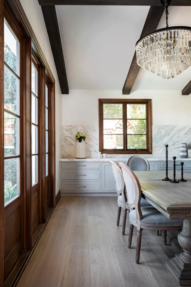 Dining room with dark wood beams and crystal chandelier